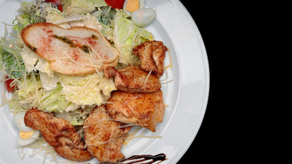 Salad with chicken fillet, eggs, on a black background with space for text