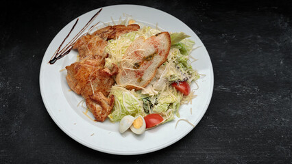 Salad with chicken fillet, eggs, on a black background with space for text