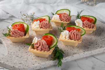 Tartlets with stuffing lying on a stone board.