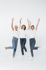 Obraz premium Positive women in jeans and t-shirts waving hands on grey background.