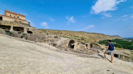 A male tourist exploring the ancient cave city of Uplistsikhe overlooking the Mtkvari river in the Shida Kartli Region of Georgia, Caucasus, Eastern Europe. Sightseeing, tourism, walking. Near Gori