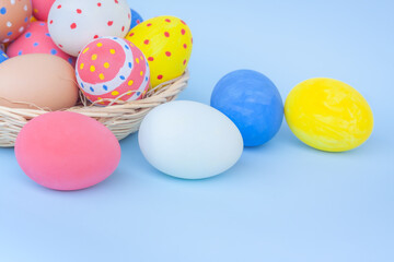 Colorful eggs in a basket on blue background	
