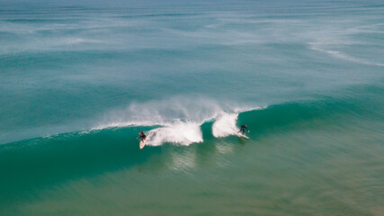 Surfers taking a wave