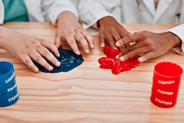 Were getting stuck in the fun of it all. Cropped shot of two unrecognizable school pupils playing and experimenting with slime in science class at school. - Powered by Adobe