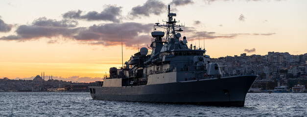 warship and cityscape at sunset