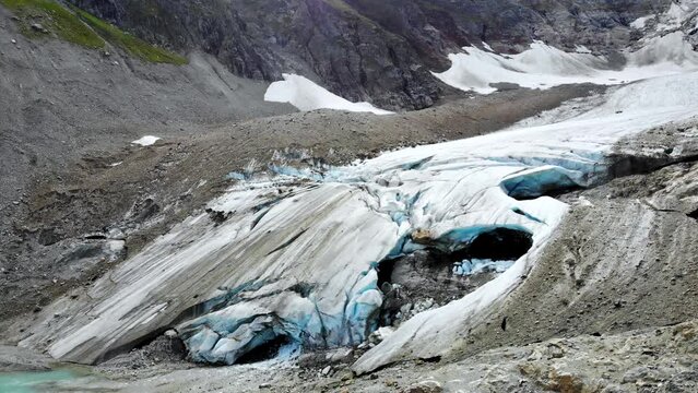 Aerial flyover over the end of Stein glacier with a view birds-eye  view of the crevasses at Sustenpass, Switzerland