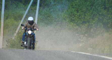 motorcyclist rides through a beautiful field