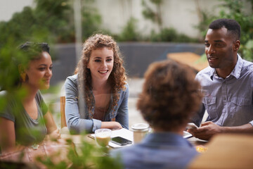Chilling with the gang. A group of young friends sitting outside at a sidewalk cafe.