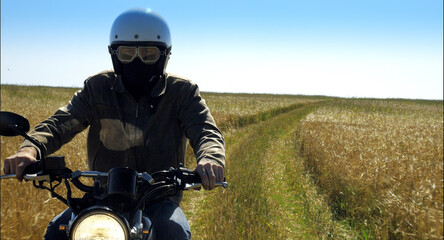 Fototapeta na wymiar motorcyclist rides through a beautiful field