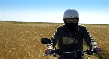 motorcyclist rides through a beautiful field