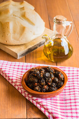 Still life with black olives, extra virgin olive oil and bread.