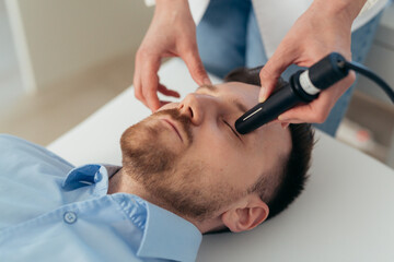 man has eyesight examination at clinic with ultrasound scanner