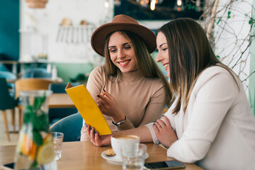 women looking menu in restaurant