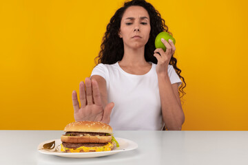 Portrait of Pensive Lady Holding Apple And Burger