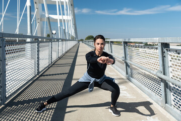 Young active sporty business woman morning routine of stretching and running exercising outdoor...
