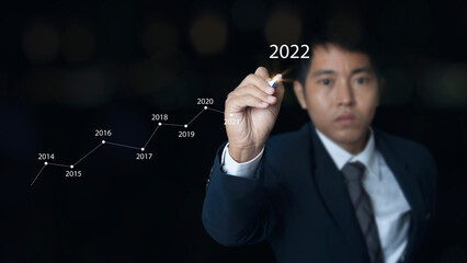 Businessman pointing spot with a pen writing on the graph finance chart growing stock market.