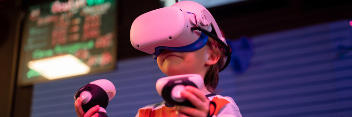 vr game and virtual reality. kid boy gamer six years old fun playing on futuristic simulation video...
