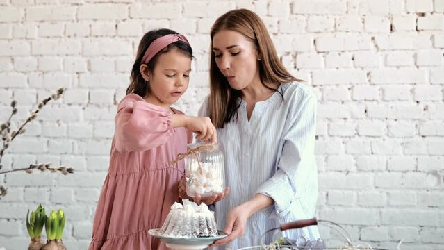 The girls' hands are sitting on the ester. The mouth of the festival is Esther Brad Into Pieces. The girl decorates Esther Brad.