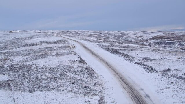 North York Moors snow scene, slow drivet into path of car traversing snow covered moors road in winter. DJI Inspire 2 Prores Winter late 2021.