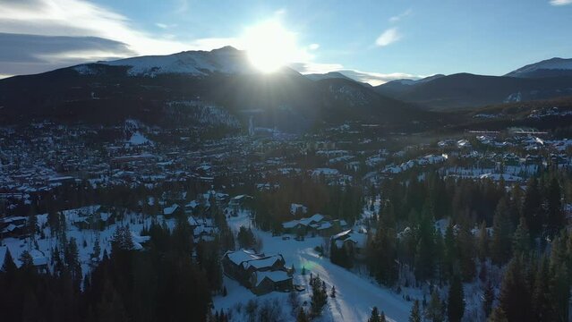 Sunrise over distant peaks in Snowy Moraine Park Colorado.Aerial mountain recreation area winter snow follow car. Aerial rural forest landscape. Alpine canyon recreation winter snow.