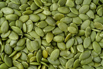 Green pumpkin seeds background. Top view