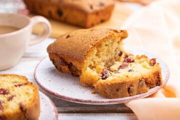 Homemade cake with raisins, almonds, soft caramel and a cup of coffee on a white wooden background. Side view, selective focus.