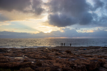 Fisherman standing on the shoreline of the south coast of South Africa