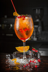 Spritz cocktail drink with orange and ice cubes on black background