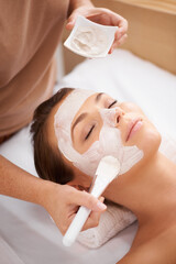 Applying a mask of beauty. Closeup of a beauty therapist applying a face mask to a client.