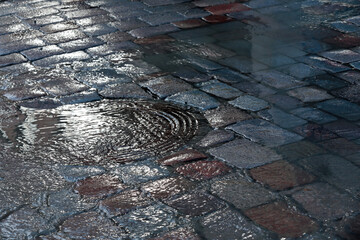 Water flowing over street inlet in spring