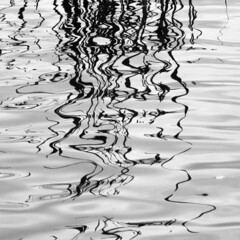Zoom background. Abstract background. Reflections spreading on colorless water and dissipating into surreal imaginary forms, close view. 