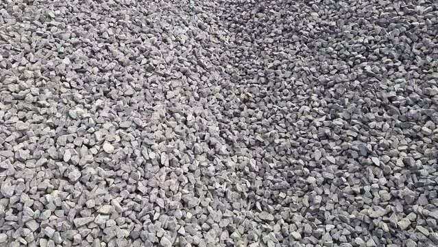 A Close Up Shot Of Black And Grey Crushed Stone Kapchi (Aggregate Crusher Stone dust ) At  A Construction Site. Camere Moving right To Left