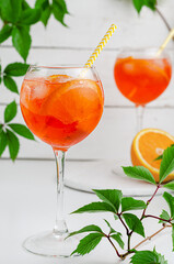 Iced aperol spritz cocktail with orange on white wooden background. Summer alcohol drink