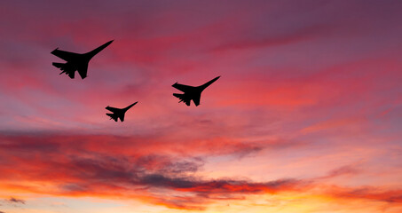War aircrafts at sunset sky.