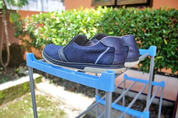 Dark blue shoes on a light blue shelf during the day