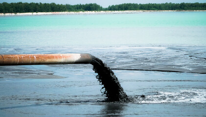 Water pollution. Dirty sewage runs from the pipe of the thermal power plant, polluting the lake....