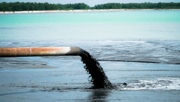 Water pollution. Dirty sewage runs from the pipe of the thermal power plant, polluting the lake. Ecology.