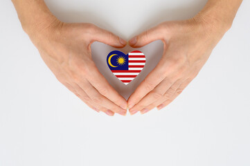 The national flag of Malaysia in female hands.