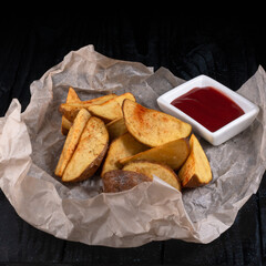 potato dips with saucesop, village potatoes with ketchup on a dark background