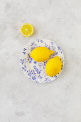 Vintage plate with lemons on vintage white background and open lemon