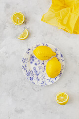Vintage plate with lemons on white background and yellow napkin