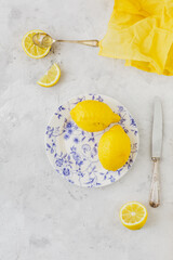 Vintage plate with lemons on white background yellow napkin and vintage knife and spoon