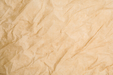 Texture of crumpled brown baking paper as background, closeup