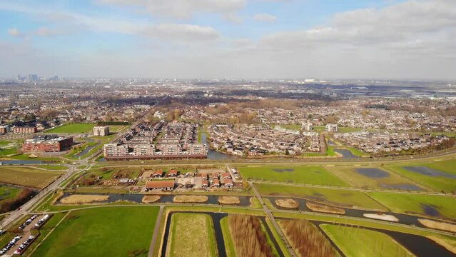 Aerial Pan Right View Across Barendrecht Green Fields And Town With Rotterdam Skyline In Distance
