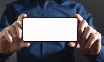 Male hands holding a smartphone with blank screen.