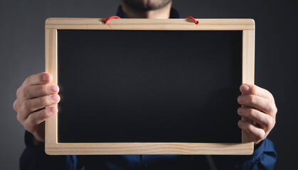 Man showing empty school blackboard.