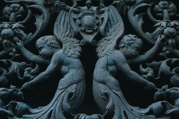 Fototapeta na wymiar PARIS, FRANCE, 08.03.2022 Forged iron angels, Indian motifs on the door.