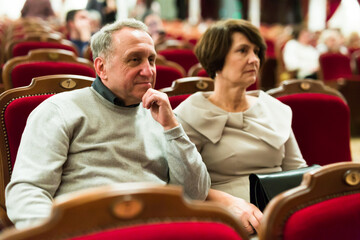 mature man and woman in theater watching a performance