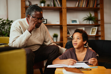 A grandfather tutoring grandchild at home.