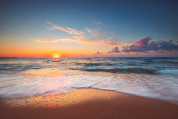 Naklejka na ściany i meble Tropical Beach sunrise over the sea shore and waves